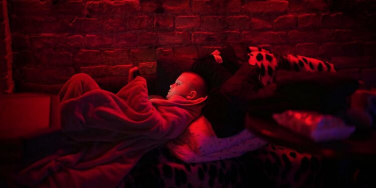 Svyatoslav, 6, plays with his tablet in a public basement used as a bomb shelter. Photograph: Emilio Morenatti/AP