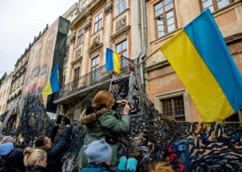 Volunteers tie pieces of fabric to make camouflage nets at the Ivanychuk Library in Lviv, Ukraine, on March 1. Ethan Swope/Bloomberg via Getty Images
