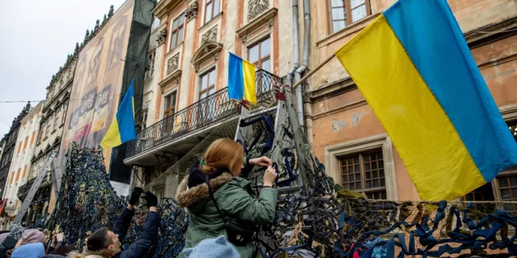 Volunteers tie pieces of fabric to make camouflage nets at the Ivanychuk Library in Lviv, Ukraine, on March 1. Ethan Swope/Bloomberg via Getty Images