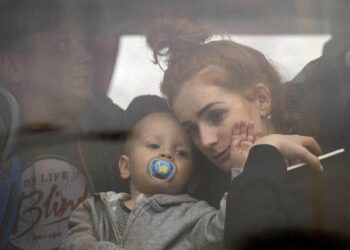 A woman holds her baby inside a bus as they leave Kyiv, Ukraine, Thursday, Feb. 24, 2022. EMILIO MORENATTI/THE ASSOCIATED PRESS