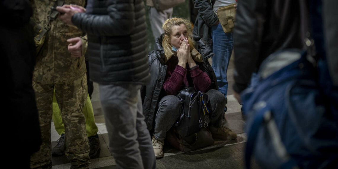 Desperate Ukrainians clambered into cars and onto train stations as they fled their cities.(AP: Emilio Morena