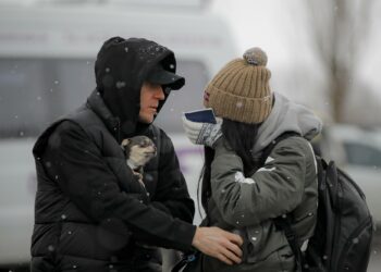 A refugee fleeing the conflict from neighboring Ukraine wipes away tears after seeing a relative at the Romanian-Ukrainian border, in Siret, Romania, Monday, March 7, 2022. (AP Photo/Andreea Alexandru)