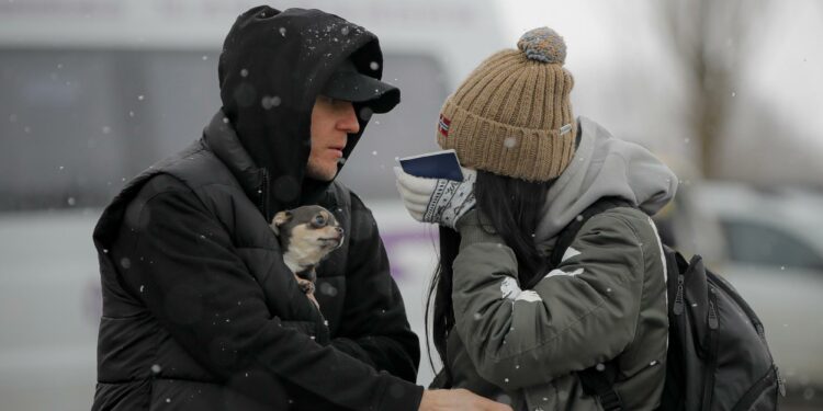 A refugee fleeing the conflict from neighboring Ukraine wipes away tears after seeing a relative at the Romanian-Ukrainian border, in Siret, Romania, Monday, March 7, 2022. (AP Photo/Andreea Alexandru)