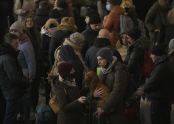 A couple talks after people rushed to board a Lviv-bound train in Kyiv, Ukraine, Monday, Feb. 28, 2022. (AP Photo/Vadim Ghirda)