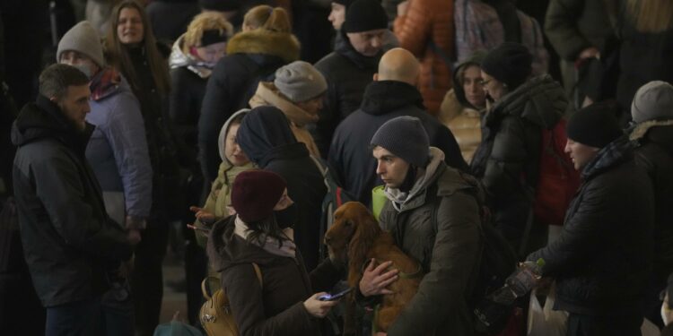 A couple talks after people rushed to board a Lviv-bound train in Kyiv, Ukraine, Monday, Feb. 28, 2022. (AP Photo/Vadim Ghirda)