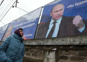 Huge placards with images of Russian President Vladimir Putin read, “Russia does not start wars, it ends them,” left, and “We will aim for the demilitarization and denazification of Ukraine” in Simferopol, Crimea, on March 4. (Stringer/AFP/Getty Images)