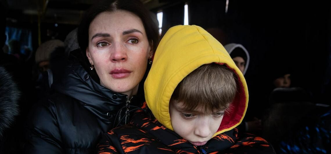 © IMF A mother and her son wait to be evacuated from the besieged city of Mikolayiv in Ukraine in March 2022.