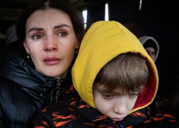© IMF A mother and her son wait to be evacuated from the besieged city of Mikolayiv in Ukraine in March 2022.