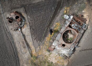 A peasant plants sunflower in his garden between the damaged Russian tank and its turret in the village of Velyka Dymerka, Kyiv region, Ukraine, Wednesday, May 17, 2023. (AP Photo/Efrem Lukatsky)