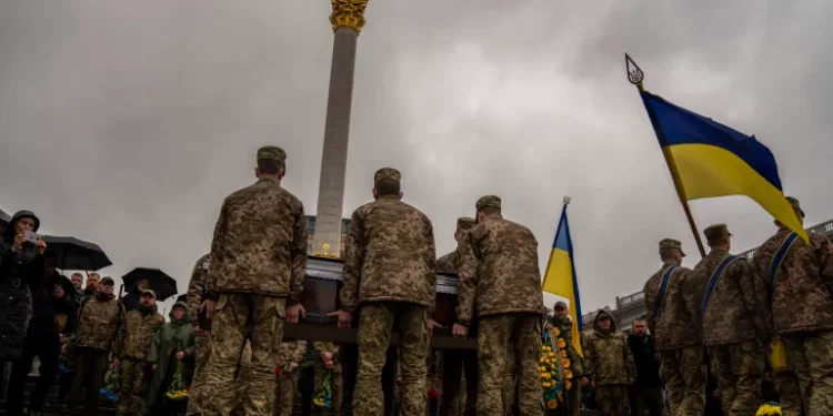 Honour guards carry the coffin of Ukrainian army paramedic Nazarii Lavrovskyi who was killed in the Kharkiv area of eastern Ukraine [Francisco Seco/AP Photo]