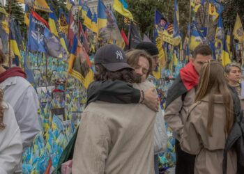 Two people embrace at a memorial for Ukrainian and foreign fighters on Defenders Day in Kyiv, Ukraine, on Oct. 1, 2024. (Roman Pilipey / AFP via Getty Images)