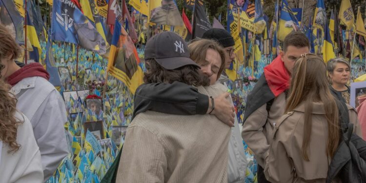 Two people embrace at a memorial for Ukrainian and foreign fighters on Defenders Day in Kyiv, Ukraine, on Oct. 1, 2024. (Roman Pilipey / AFP via Getty Images)