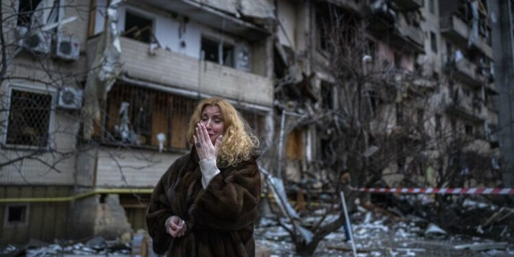 . A woman is crying in front of her house destroyed by a rocket attack. Kyiv, February 25, 2022. Photo credit: AP /Emilio Morenatti