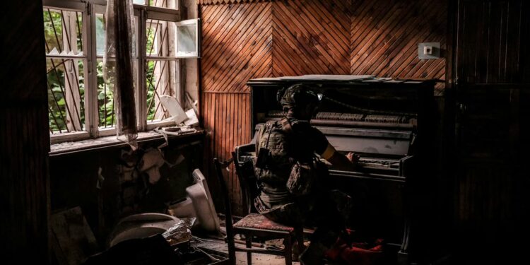 A serviceman of 24th Mechanized brigade, named after King Danylo, of the Ukrainian Armed Forces plays a piano in a damaged building in the frontline town of Chasiv Yar in Donetsk region, Ukraine, June 25. Oleg Petrasiuk/24th King Danylo Separate Mechanized Brigade