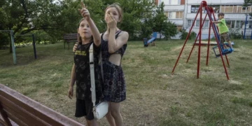 Evgeniya Kovalenko, 12, and her friend watch Ukrainian rockets streak past in the sky from the playground in front of their residential building on June 1 in Saltivka, a neighborhood in Kharkiv that has sustained severe shelling since the beginning of Russia’s full-scale invasion of Ukraine. Laurel Chor for NPR