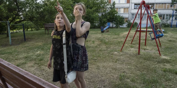 Evgeniya Kovalenko, 12, and her friend watch Ukrainian rockets streak past in the sky from the playground in front of their residential building on June 1 in Saltivka, a neighborhood in Kharkiv that has sustained severe shelling since the beginning of Russia’s full-scale invasion of Ukraine. Laurel Chor for NPR